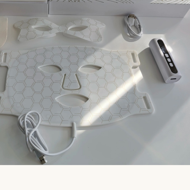 White Amporea LED mask kit accessories — eye mask, charging cable and controller wand